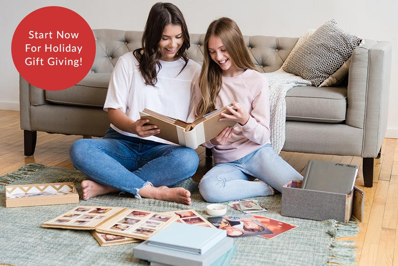 Two young women looking through a family album of photographs