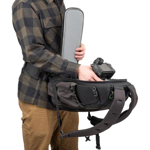 The Think Tank Backlight bag is attached to a person's body demonstrating how it opens to easily access the camera gear without removing from the body.